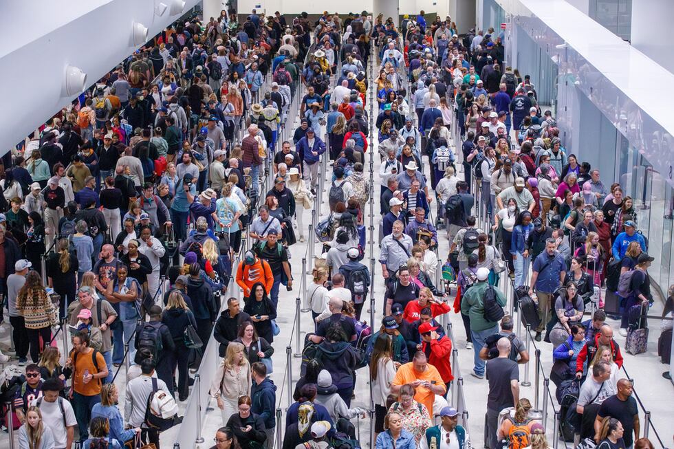 Viajeros hacen fila para pasar por el control de seguridad de la Administración de Seguridad...