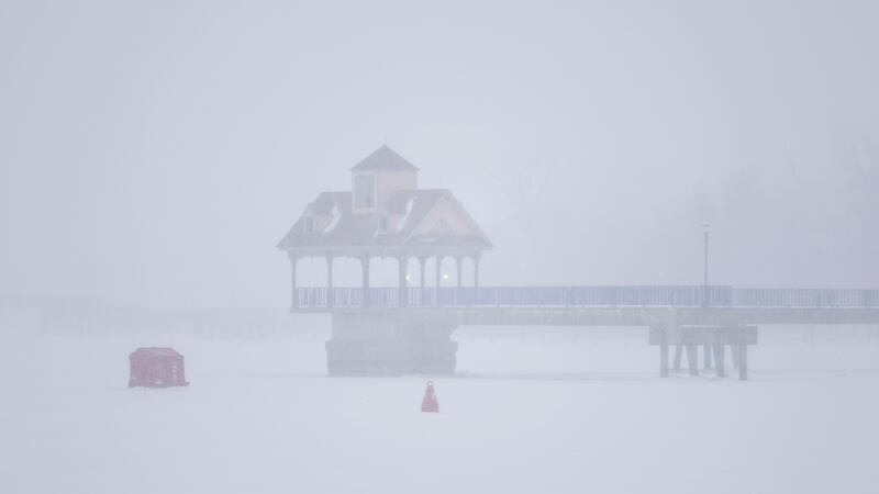 Una choza roja ha sido colocada sobre el hielo del río Saginaw mientras una tormenta de nieve...