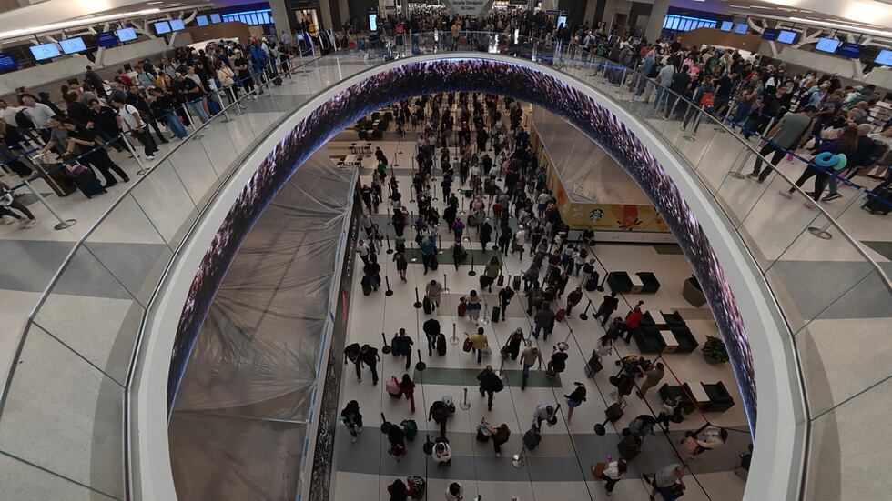 Viajeros hacen fila para pasar los controles de seguridad en el Aeropuerto Intercontinental...
