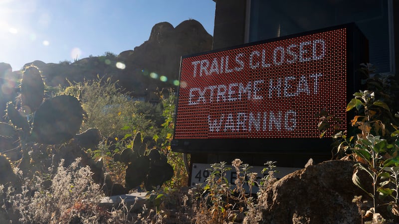 Un letrero avisa que un sendero para excursionistas está cerrado debido al exceso de calor, en...