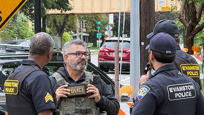 Esta foto, proporcionada por Ryan Garton, muestra a un agente federal hablando con policías el...